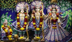Beautifully adorned Hindu statues with vibrant floral garlands and intricate attire in a temple setting.